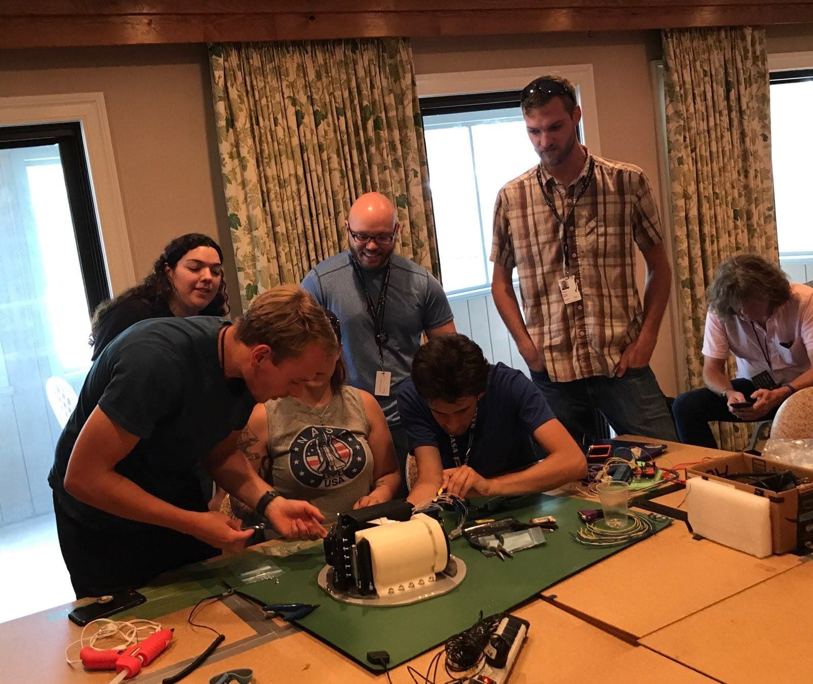 A RockSat student team assembling their satellite payload on the table in the meeting room at the Refuge Inn, Chincoteague Island.