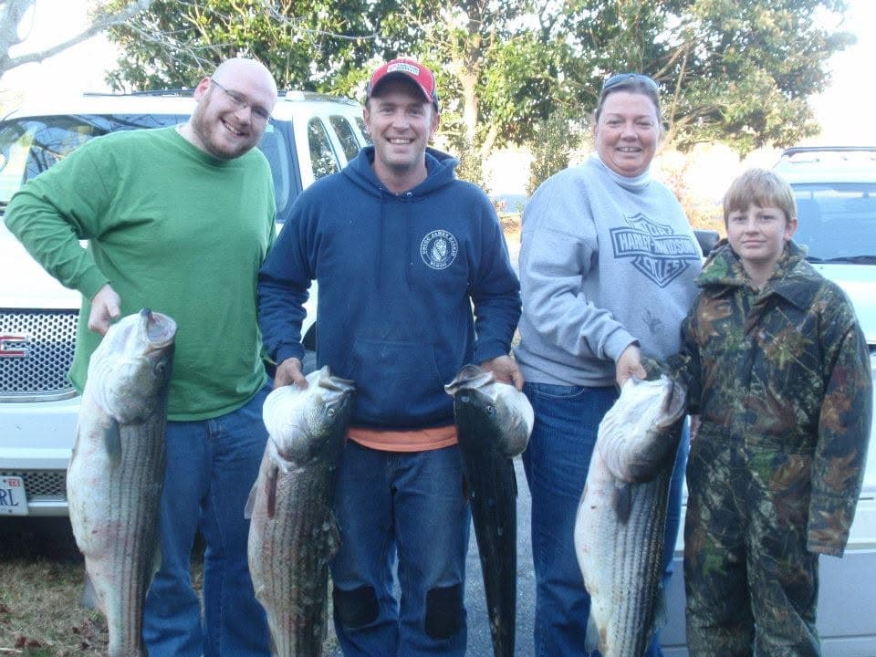 Four members of the Leonard family holding striped bass caught on the Chesapeake Bay in November.