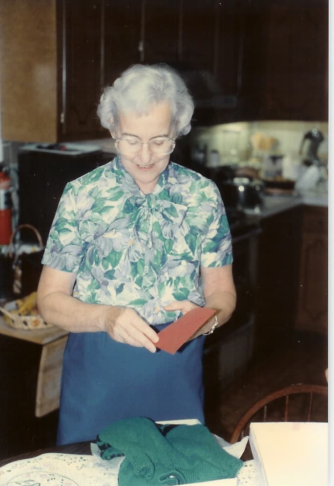 Martha Leonard opening an envelope in her tiny apartment kitchen at the Refuge Motor Inn