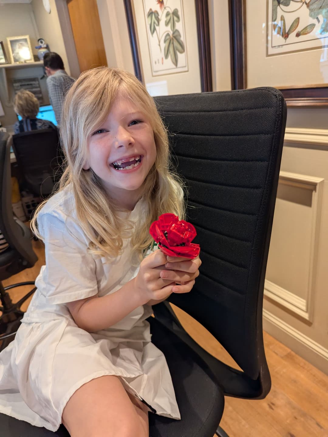 A young member of the fourth generation at the Refuge Inn front desk, holding a red rose.