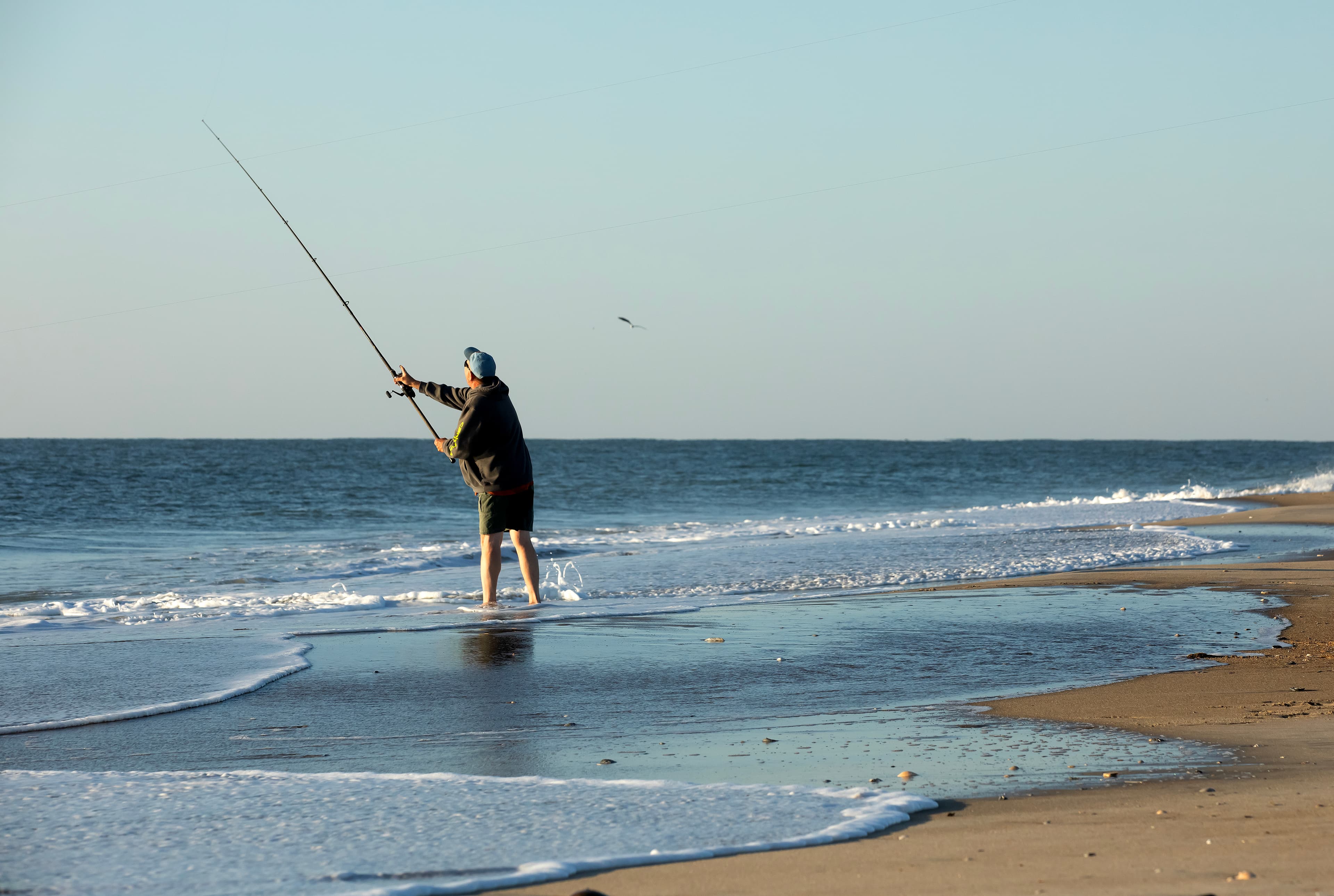 A surf fisherman casting into the breakers from the beach on Assateague Island.