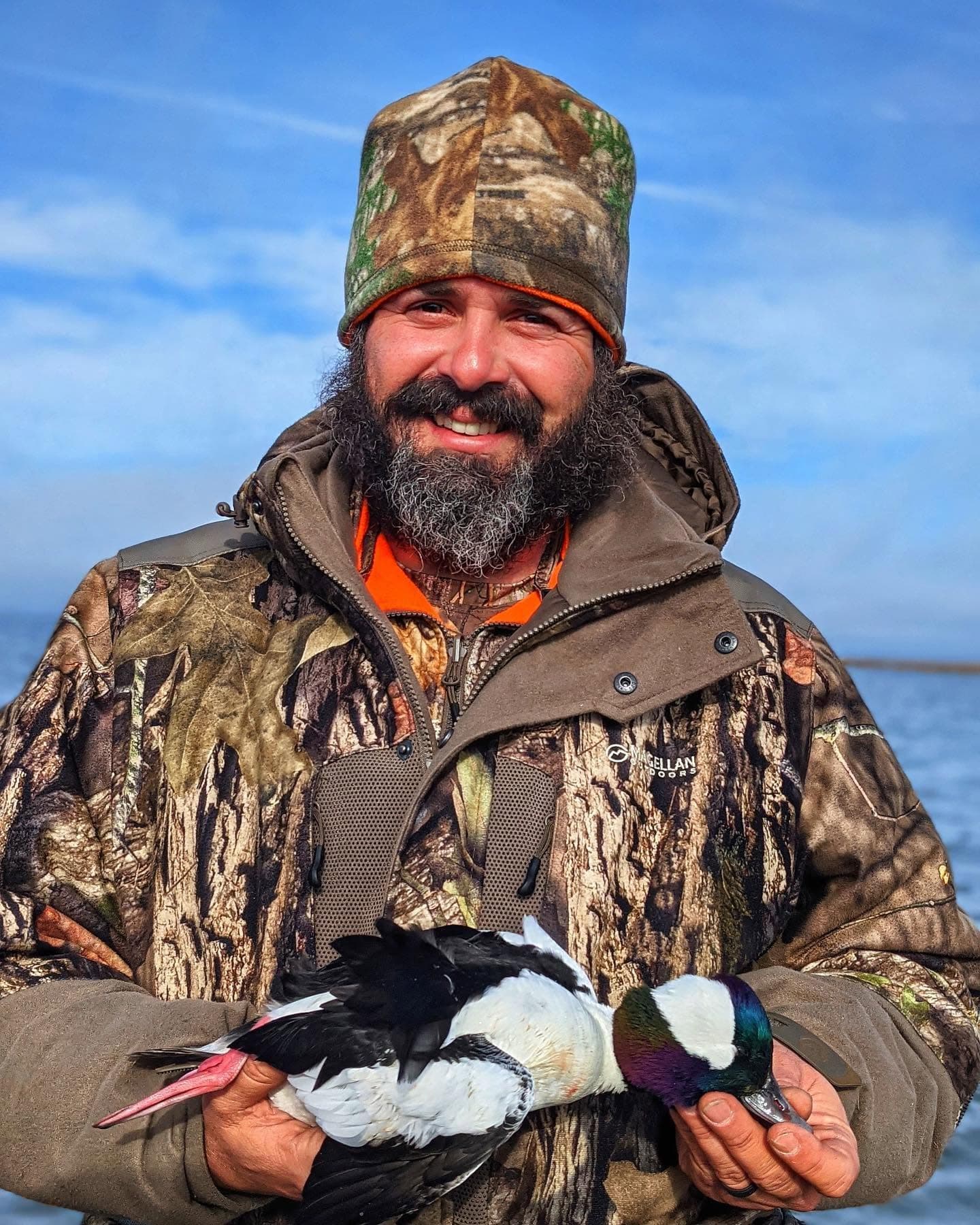 A hunter on Chincoteague holding a pair of drakes taken on the channels, a bufflehead among them.