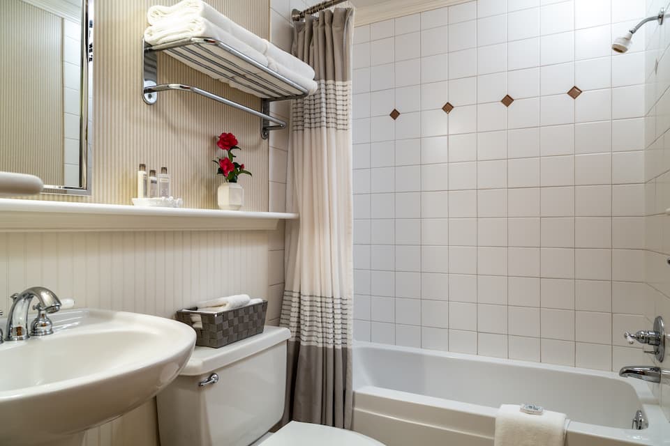 A tidy bathroom featuring a bathtub, sink, and neatly arranged towels.