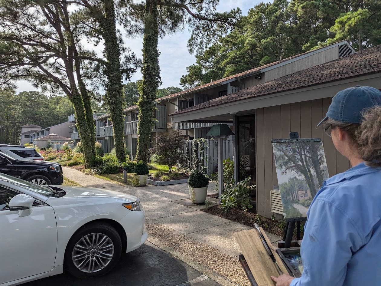 An artist painting on the grounds of the Refuge Inn during a plein air workshop on Chincoteague Island.