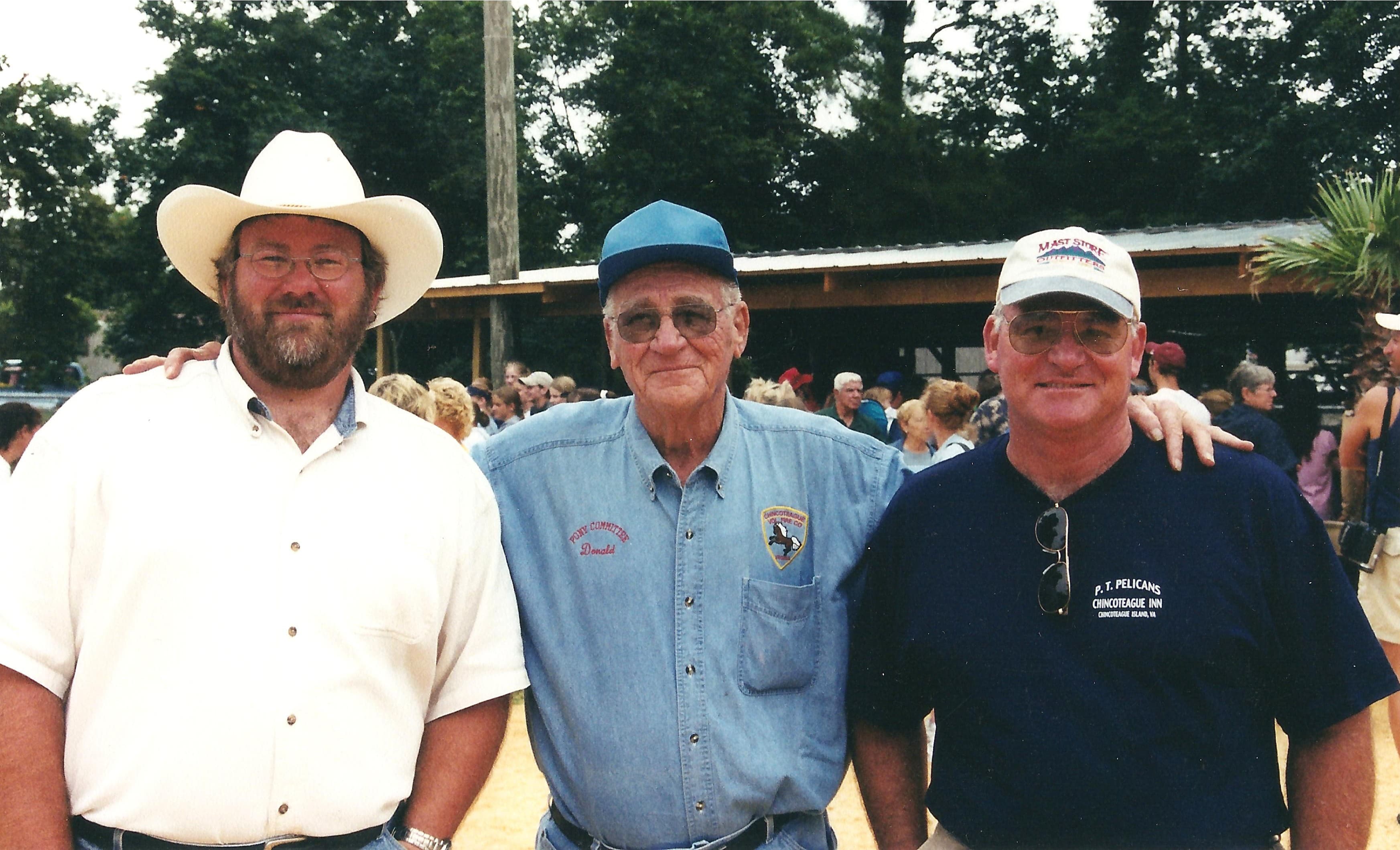 Arthur, Donald, and Carlton Leonard posing together at the annual wild pony auction, hosted by Chincoteague Volunteer Fire Company.